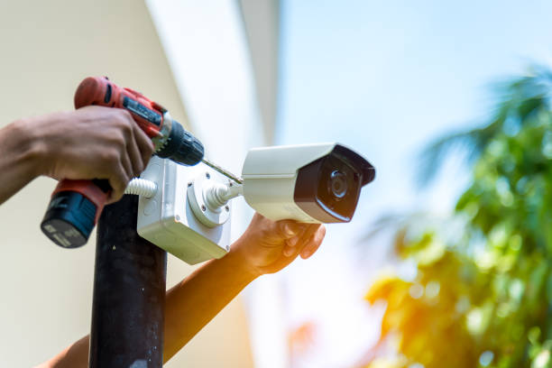A Wireless CCTV camera setting outside building with white box water poof with sun blur background.